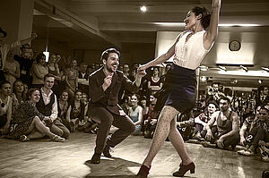 Tanzender Mann und Frau mit Publikum
