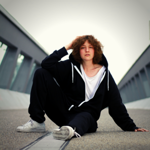 Bi Män mit Hoodie auf der Donnersberger Fußgängerbrücke am Boden sitzend