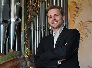 Organist Aaron Voderholzer vor einer Orgel