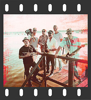 Sechsköpfige Band auf einem Steg am See