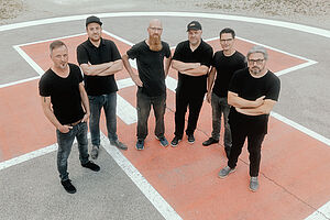 Bandmitglieder von Hunzgrippe mit schwarzer Kleidung auf einem Platz posierend