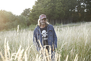 Musiker Jol Rose in einem Feld stehend