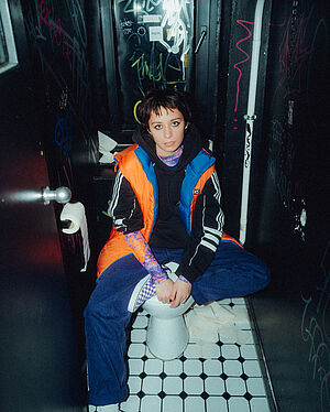Paula Carolina sitting on a toilet