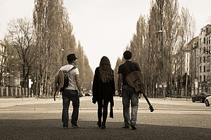 Band MadButFine von hinten auf einer Allee fotografiert