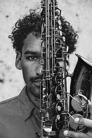 CELLZ - ein junger Mann mit einem Saxofon vor dem Gesicht