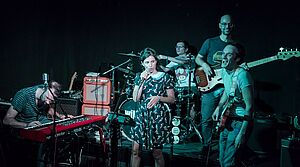 Band Intimissimi auf Bühne mit Instrumenten und bläulich angesrahlt