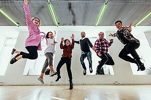 Sechs springende Personen in einem Tanzraum