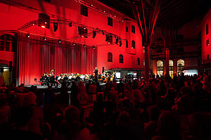 Schalterhalle in rot beleuchtet beim Konzert der Münchner Symphoniker