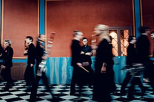 Musiker laufen von rechts nach links durch einen Raum